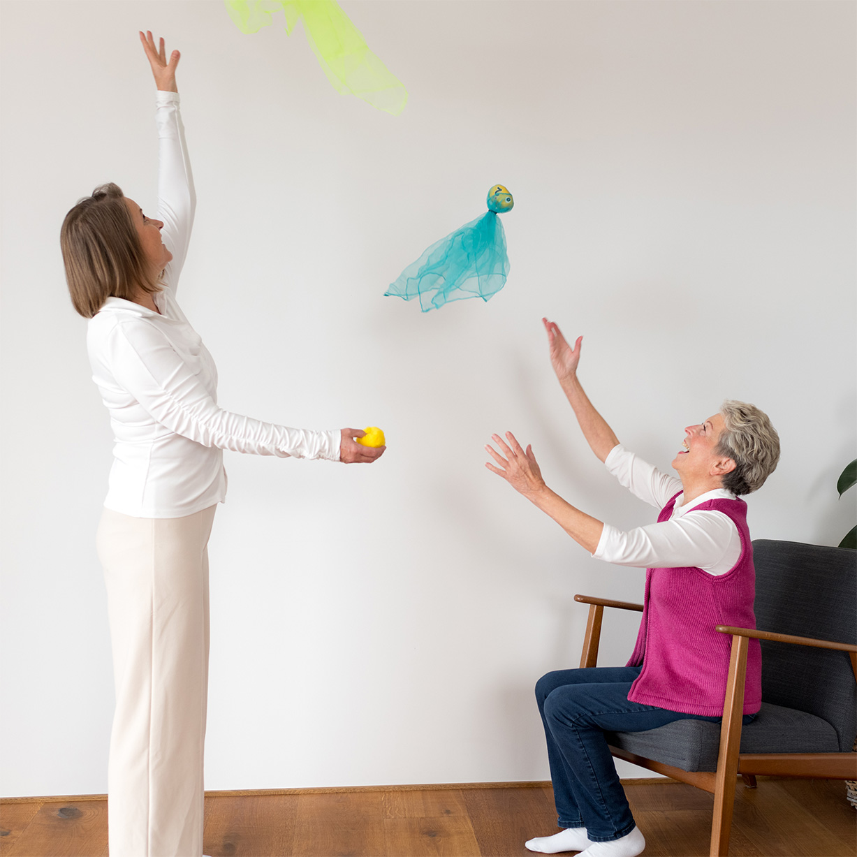Susann Quade, zertifizierte Life Kinetik®-Trainerin führt gemeinsam mit Seniorin Life Kinetik®-Übung mit Tüchern durch